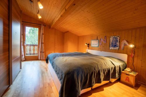 a bedroom with a bed in a wooden room at Chalet Le Ruissel - 6 personnes - confortable et bien situé in Gryon