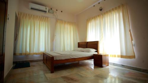 une chambre avec un lit et une grande fenêtre dans l'établissement Green Nestle Heritage Homestay, à Kaduturutti