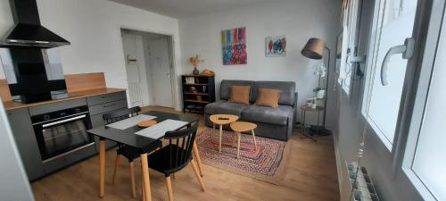 un salon avec un canapé et une table dans l'établissement Du bonheur à la clé - T2 hyper centre, à Concarneau