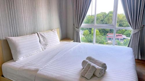 1 cama con toallas y ventana en spacious and modern Apartment in Ao Nang, en Ban Khlong Haeng