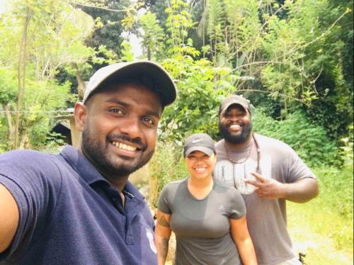 two men and a woman standing in a forest at The Happy House Nature Retreat in Talakolawela