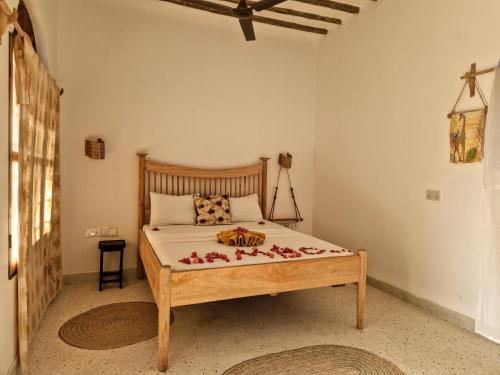 a bedroom with a bed with flowers on it at ZamZam House in Jambiani