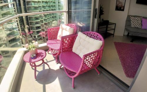 a group of chairs and tables on a balcony at Dominiks pink dream Studio Balcony Ocean View Balcony Fast-Wifi at Tambuli Resort High Floor in Maribago