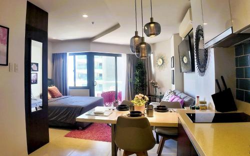 a living room with a bed and a desk in a room at Dominiks pink dream Studio Balcony Ocean View Balcony Fast-Wifi at Tambuli Resort High Floor in Maribago