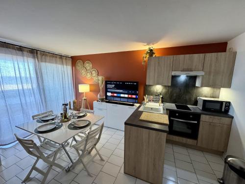 une cuisine avec une table et des chaises dans une pièce dans l'établissement Le Balcon Des Vagues, à Canet