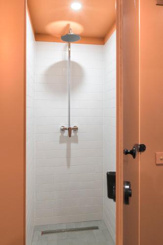 a bathroom with a shower with white tiles at Vibe Loft free drink daily by Zazi in Bratislava