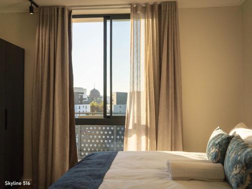 a bedroom with a bed and a window with a view at On Park 516 At Century City in Cape Town