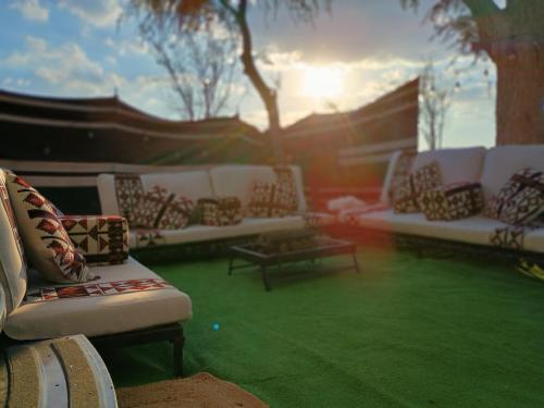 a group of white couches sitting on a green lawn at Rehla Rv Camper Van in Al Ain