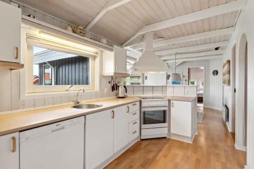 a kitchen with white cabinets and a sink at Lovely Summer House With Sea View in Haderslev