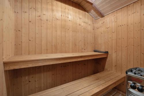 a sauna with wooden walls and a wooden shelf at Lovely Summer House With Sea View in Haderslev