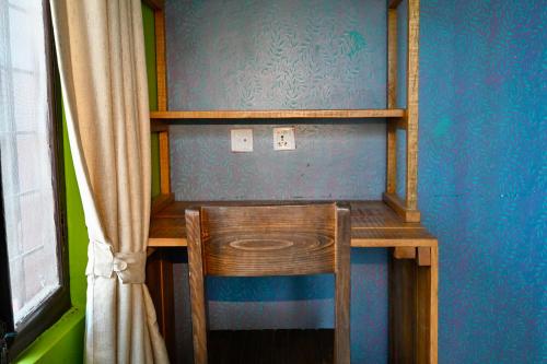 a wooden desk with a chair in a blue room at Barang Village Community Homestay in Pokhara