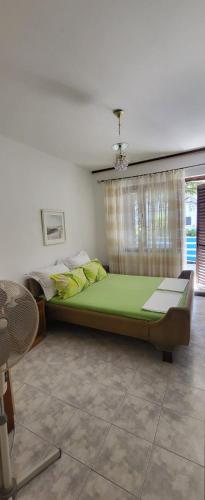 a bedroom with a large green bed with a window at Residence Paula in Jadranovo