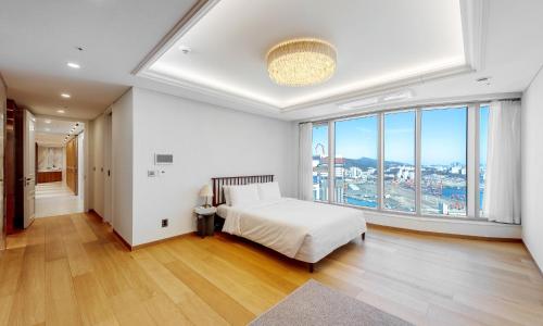 a bedroom with a bed and a large window at Busan Station BOOKING THE BAY in Busan