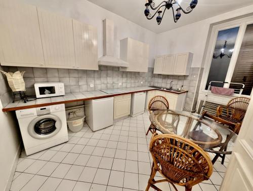 - une cuisine avec des appareils blancs, une table et des chaises dans l'établissement Large 2-bedroom apartment large living room with parking near train station and downtown, à Grenoble