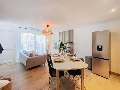 Il dispose d'une cuisine et d'un salon avec une table et un réfrigérateur. dans l'établissement L'EVASION appartement entièrement rénové à 15min de Genève, à Viry