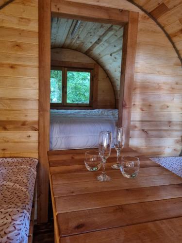 a table with wine glasses on it in a cabin at Le Moulin de Vilaine in Châteauroux