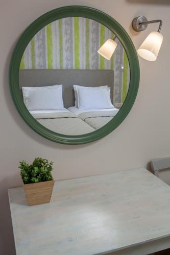 a mirror over a table with a bed in a room at Hotel Pitsakis in Tolo