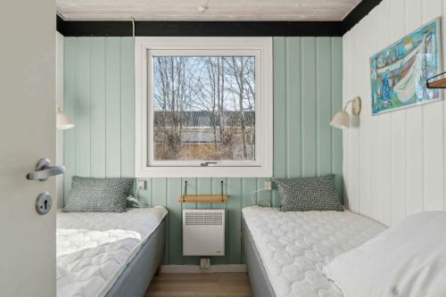 two beds in a room with a window at Cottage Near Idyllic & Peaceful Sandy Beach in Rønne