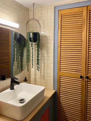 une salle de bains avec un lavabo blanc et un miroir dans l'établissement Maison Honorine, à Saint-Geniès