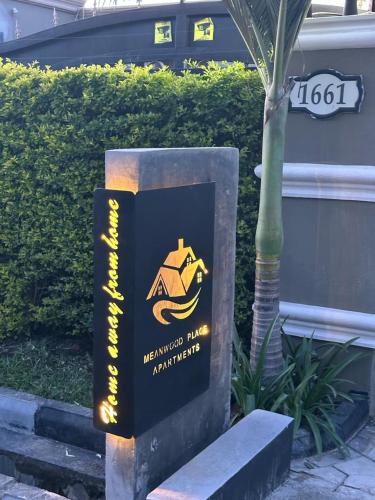 a sign for a building with a logo on it at Meanwood Place Apartments in Lusaka