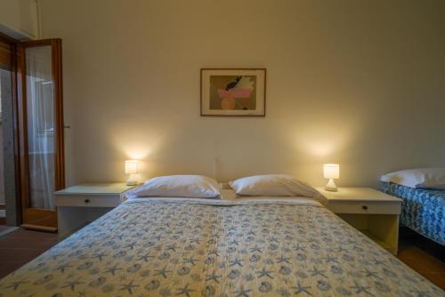 a bedroom with a bed with two lamps on it at Hotel Da Ruggero - 100m dal Porto in Giglio Porto