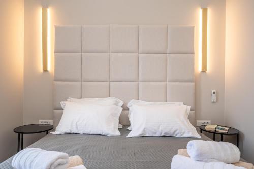 a bedroom with a large white headboard and white pillows at Assos Rockshore Villa by the sea in Asos