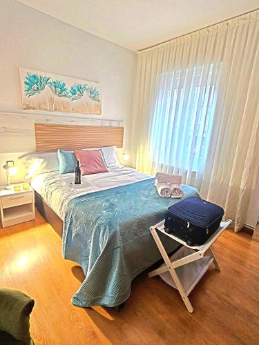 a bedroom with a bed with a suitcase on it at Apartamento Logroño Ayuntamiento, centrico in Logroño