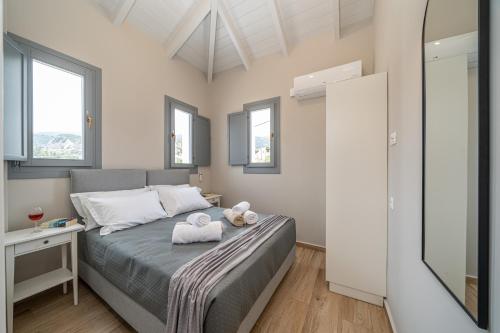 a bedroom with a bed with two teddy bears on it at Assos Rockshore Villa by the sea in Asos