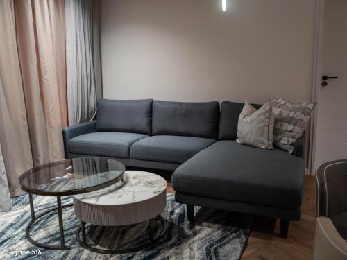 a living room with a blue couch and a table at On Park 516 At Century City in Cape Town