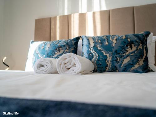 a bed with two rolled towels and pillows at On Park 516 At Century City in Cape Town