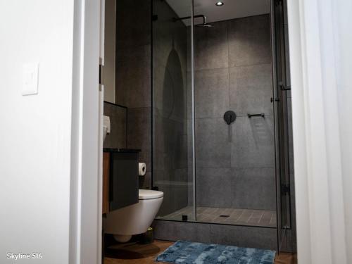 a bathroom with a glass shower with a toilet at On Park 516 At Century City in Cape Town