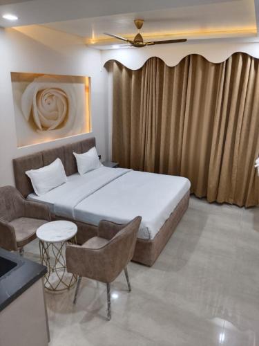 a bedroom with a bed and a couch and a table at Leisure Homes in Lucknow