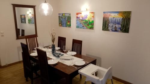 une salle à manger avec une table, des chaises et des peintures dans l'établissement Loft en duplex avec vue sur plage et chenal, à Dieppe