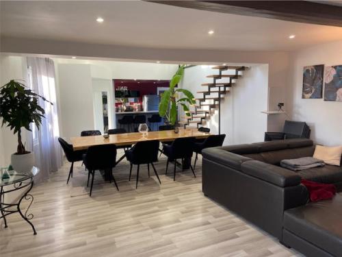 un salon avec une table, des chaises et un canapé dans l'établissement Au plaisir du lac, à Sainte-Marie-du-Lac-Nuisement 