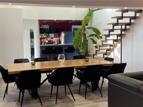 une salle à manger avec une table en bois et un escalier dans l'établissement Au plaisir du lac, à Sainte-Marie-du-Lac-Nuisement 