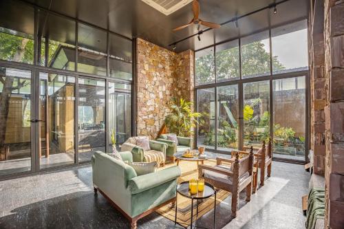 a living room with furniture and large windows at ELIVAAS Hari Bagh 4 BHK Villa with Gaming Zone & Art Nook in Jaipur