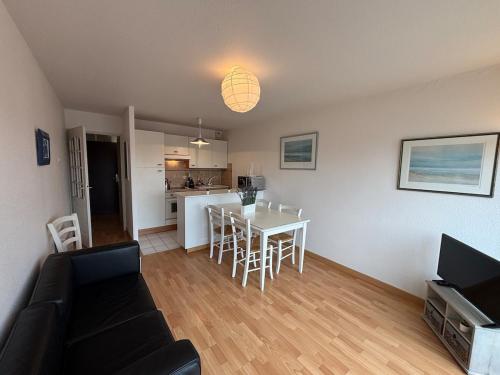 Il comprend un salon et une cuisine avec une table et des chaises. dans l'établissement Duplex Blue Marine, à Le Touquet-Paris-Plage