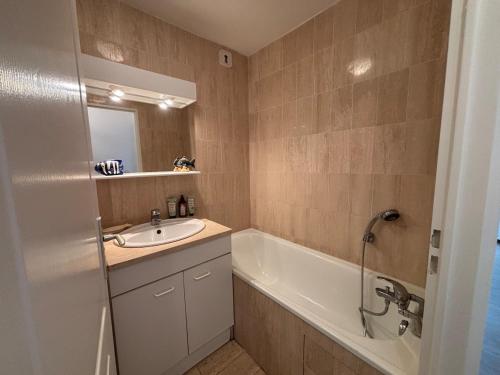 une salle de bain avec une baignoire et un lavabo et une baignoire dans l'établissement Duplex Blue Marine, à Le Touquet-Paris-Plage