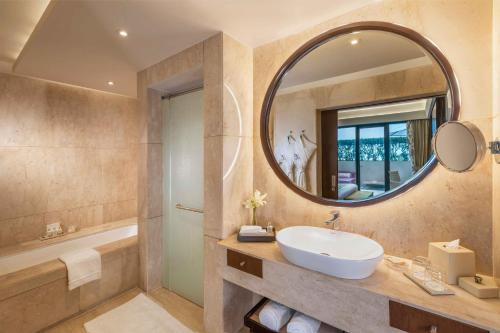 a bathroom with a sink and a mirror at The Leela Ambience Convention Hotel Delhi in New Delhi