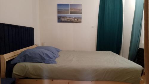 sypialnia z łóżkiem z niebieskimi zasłonami w obiekcie T2 60m² vue panoramique sur port et mer w mieście Dieppe