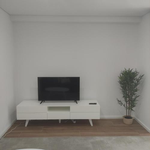 a living room with a tv on a white cabinet at Lima Zen Exclusive Apartment With View in Ponte de Lima