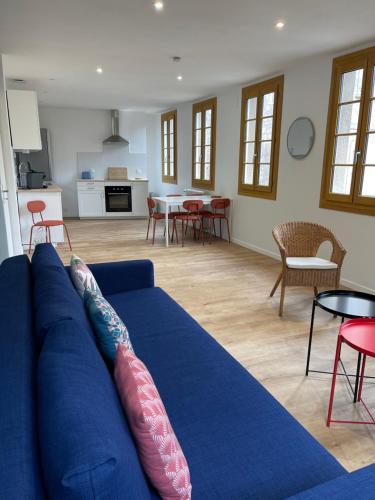 un salon avec un canapé bleu et une cuisine dans l'établissement L'Architecte, à Figeac