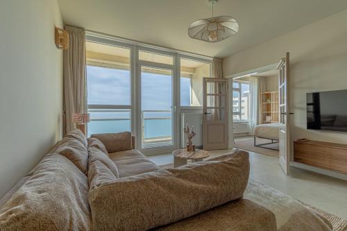 sala de estar con sofá grande y TV en Casa Buena Vista, en Egmond aan Zee