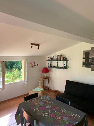 un salon avec une table et un canapé dans l'établissement Gîte de vacances, à Saint-Michel-de-Fronsac