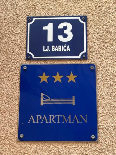 a blue sign on the side of a wall at Apartman Slavica self check in,private parking in Osijek