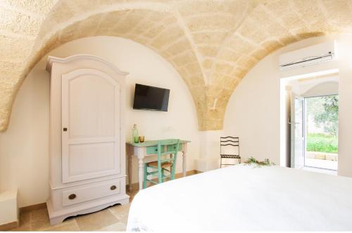 a bedroom with a bed and a tv on the wall at Tenuta Mogavero in Torre Canne