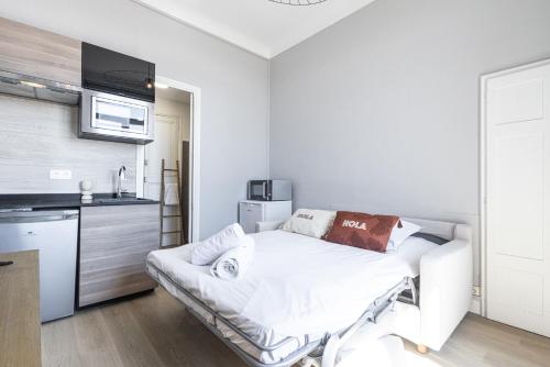 Cette chambre blanche dispose d'un lit et d'une cuisine. dans l'établissement Coquette studette, aperçu mer, à 400m des plages, à Villeneuve-Loubet