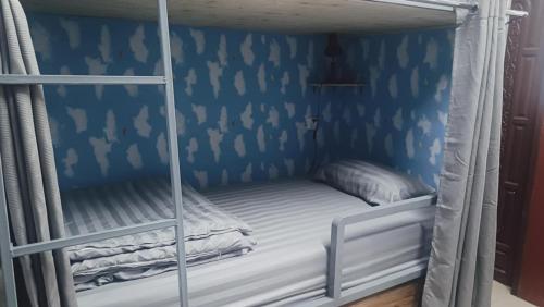 a bunk bed in a room with a blue wall at Jasmine Hostel & Guesthouse in Pakse