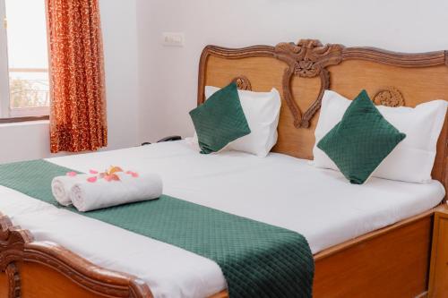 two beds in a room with green and white pillows at Hotel Victoriya Palace,Mcleod Ganj in McLeod Ganj