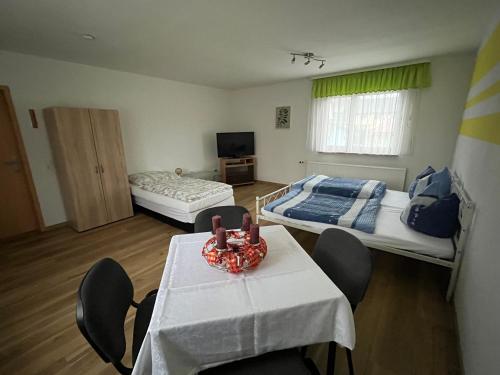 una habitación con dos camas y una mesa y sillas en Schöne Zimmer mit gemeinsamer Nutzung von Bad, Toilette und Küche, en Schwarzbach